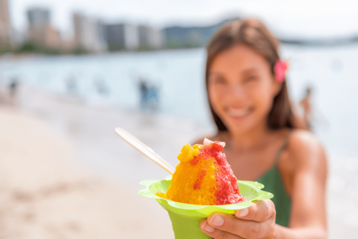 girl holding a cup of colorful shaved ice in hawaii