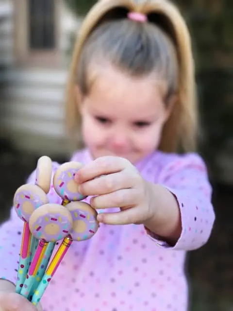 Kid holding donut erasers to go with printable Valentines cards