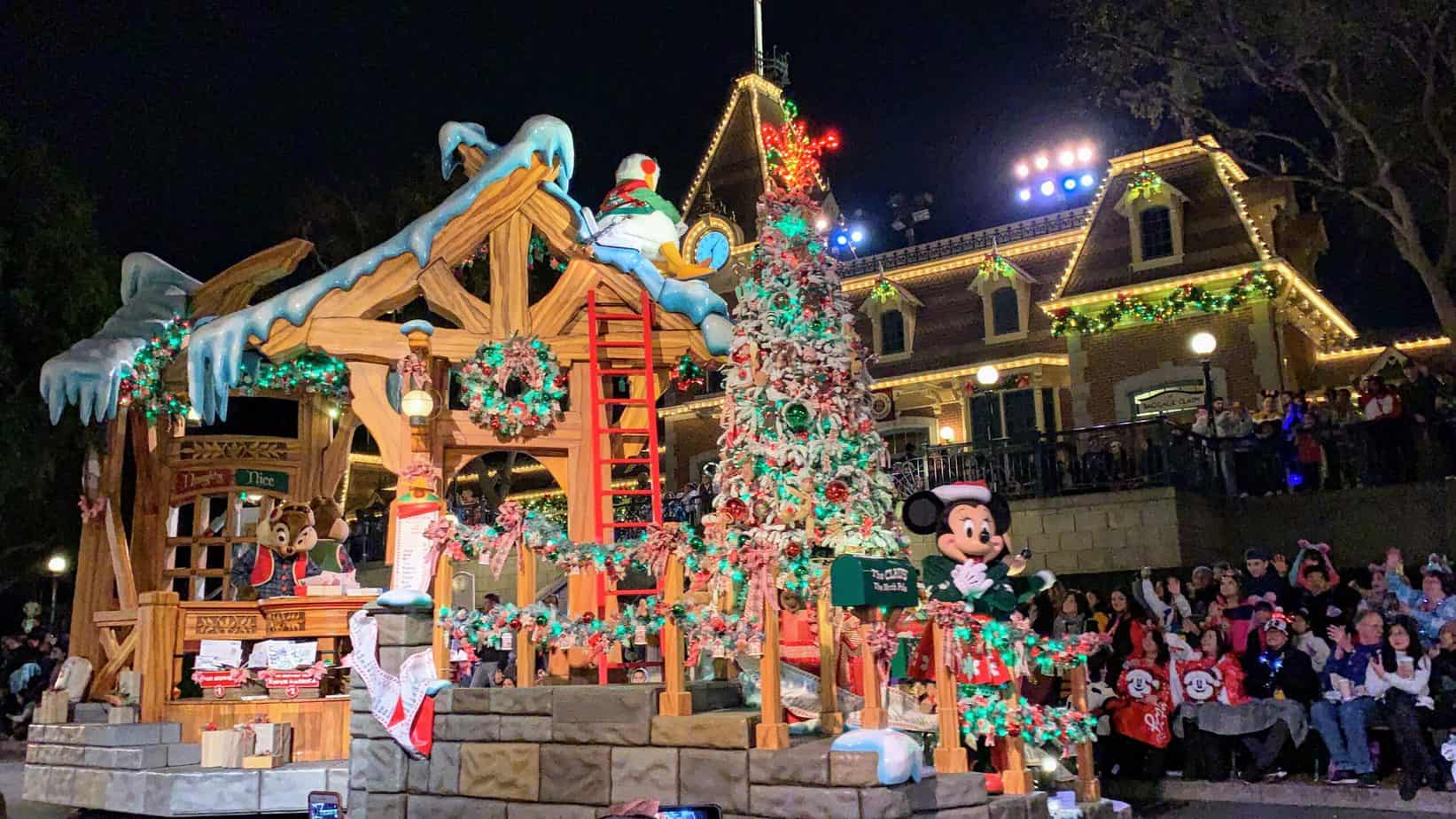 mickey mouse in front of a christmas tree at the disneyland christmas parade