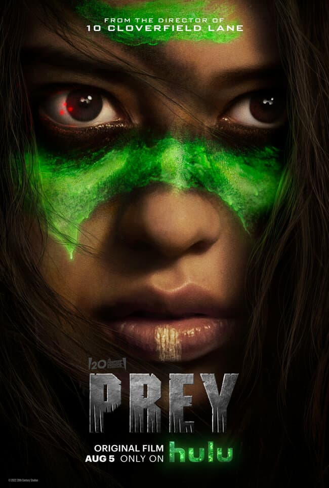 Young woman stares fiercely with glowing green paint dripping from her face. Movie quotes from Prey.