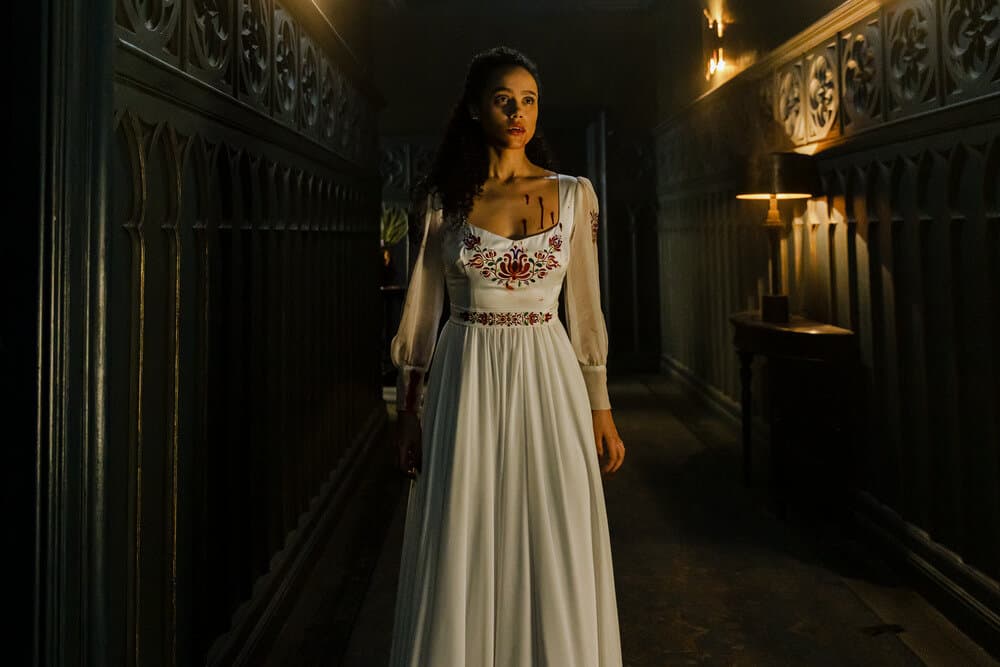 lines of dialogue from The Invitation 2022. lady in white wedding dress in a dark hallway.