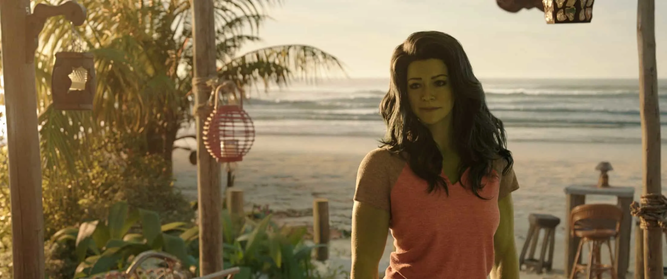 SheHulk (Large green woman) standing facing away from a beach, on a porch. Quotes from SheHulk