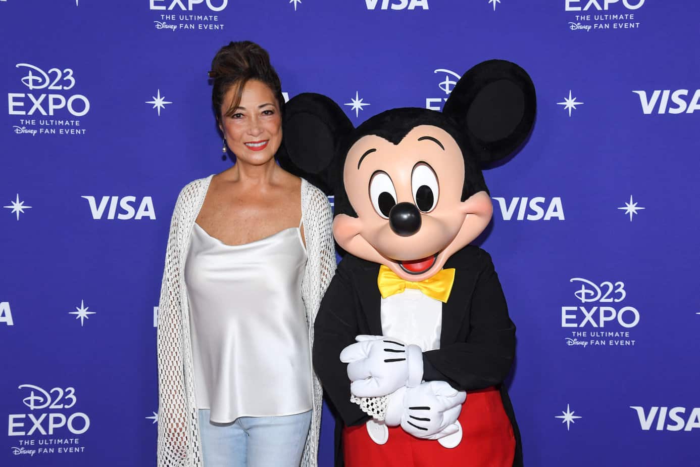 2022 Disney legend Doris Hardoon standing next to Mickey Mouse.