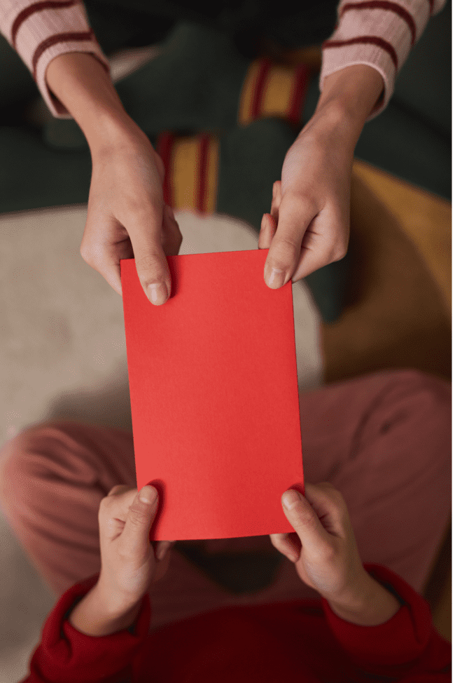 Red envelope held by two people on either side Spoilers without context glass onion
